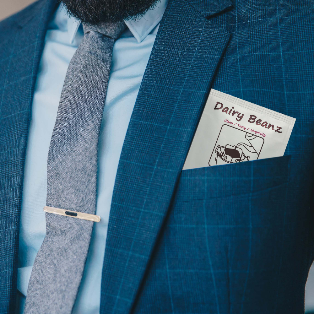 A pack of Beanz Drip peeking out of a businessman's suit front pocket, emphasizing portability.