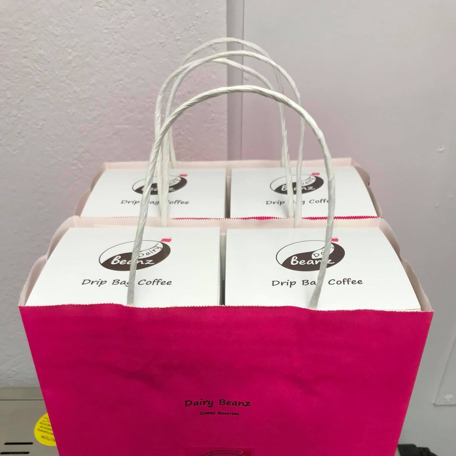 Boxes of Beanz Drip coffee packed in a pink portable gift paper bag, perfect for gifting.