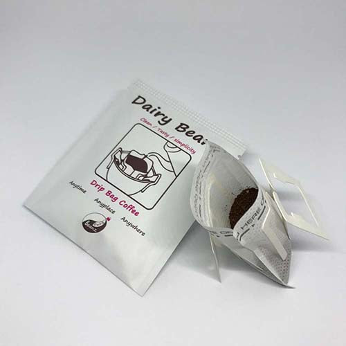 A pack of Beanz Drip alongside an opened drip bag, showing the packaging and coffee inside.