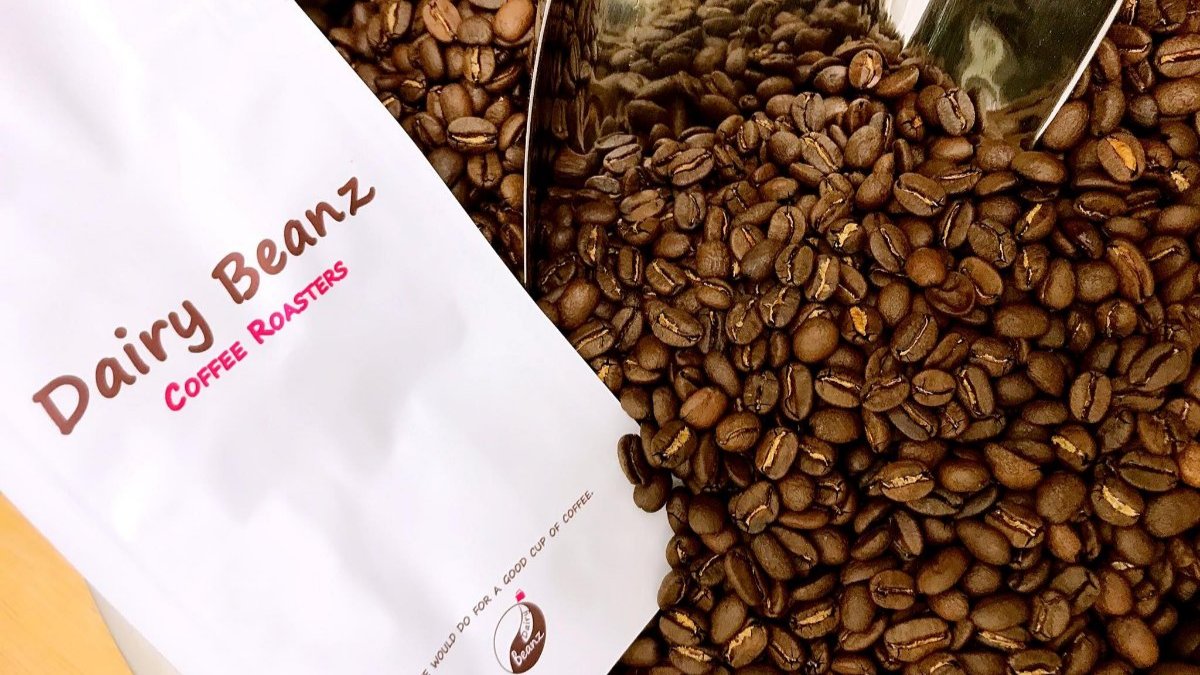Homepage banner image featuring fresh coffee beans with white, coffee-colored, and pink text on a Dairy Beanz bag: "Ready to fill it up."